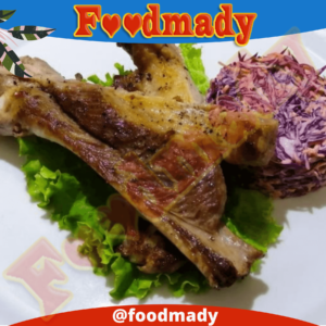 Grilled pork rib in a plate with shredded red cabbage and carrot